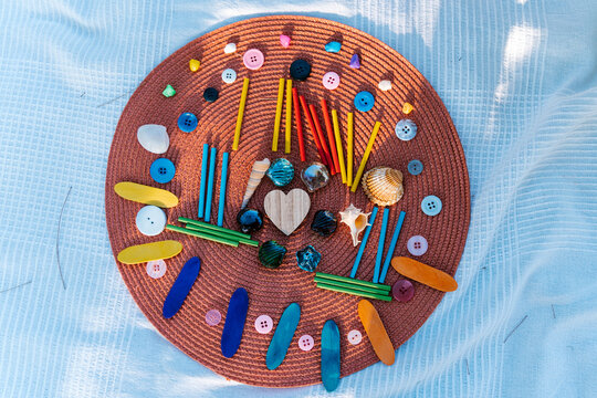 Colorful decorative items with seashells on wicker mat