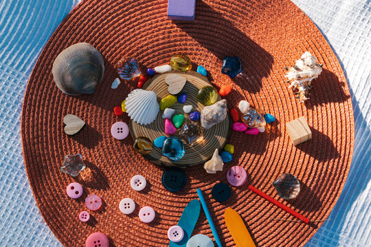 Colorful buttons and stones with shells on wicker mat