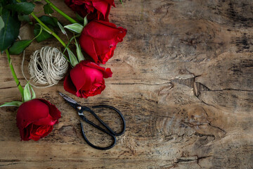 red roses twine scissors on wood table