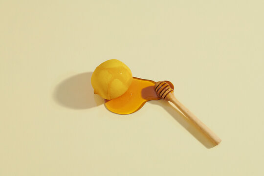 Honey and lemons on a ligth yellow background closeup