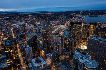 Seattle, Washington, USA - Jan. 2023, night aerial view of illuminated Seattle Downtown with skyscrapers, traffic on streets, Lake Union with famous Space Needle Tower in backgroun - aerial night view