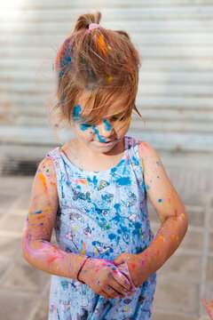 Cute child with colorful paints on face and body
