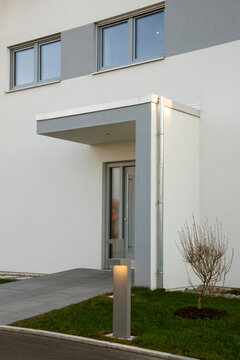 modern gestalteter Hauseingang mit Vorgarten und Windfang und Beleuchtung
