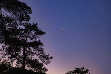 A bright comet in the sky, a shooting star. Comet tail at sunset. Selective focus.