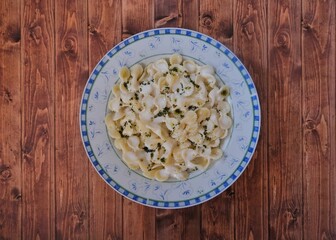 Pasta with yogurt and sauce. Background wooden floor.