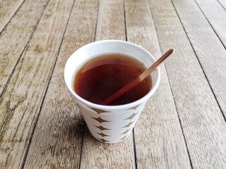 Drinking tea in a cardboard cup.