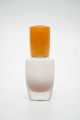 Pearl white pump bottle with orange cap on white background.