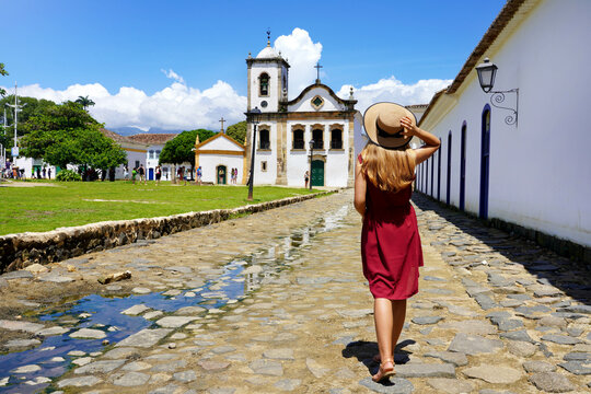Tourism in Brazil. Back view of beautiful girl with walking towards the Church of Saint Rita of Cassia in Paraty, Brazil.