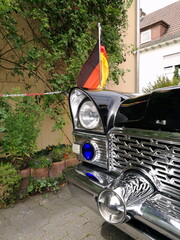 Blaulicht unter dem Scheinwerfer einer schwarzen Staatskarosse der Sechzigerjahre aus der...