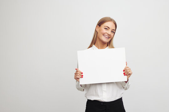 Beautiful young business woman holding blank paper sheet contract with a happy face and big smile. 