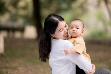 Portrait of asian mother playing with newborn baby