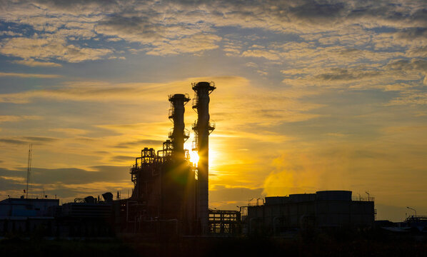 Silhouette of gas turbine power plant at sunset which create pollution and global warming cause ozone layer depletion for electricity and energy concept