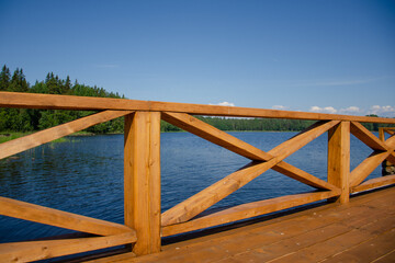 A new wooden jetty on the calm waters of a lake on a sunny summer day. Clear blue skies and calm weather