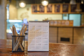 2023 Calendar desk place on table. Desktop Calender for Planner to plan agenda, timetable, appointment, organization, management each date, month, and year on wooden office table.Calendar Concept.