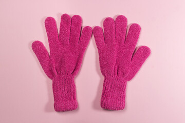 Pink gloves on a pink background. Winter accessory