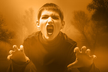 Portrait of the fierce boy vampire attacking with long sharp teeth on a stormy night