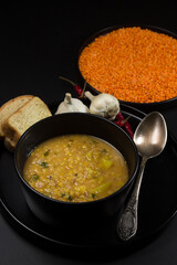 Portion of lentil soup on a black background. traditional cooking