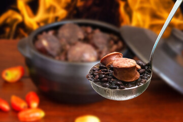 Feijoada. Traditional Brazilian food. ladle with feijoada highlighted and blurred background