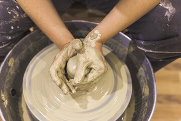 Pottery workshop. Closeup of woman artist hands molding clay on pottery wheel. Creative handmade craft. Ceramic art studio.