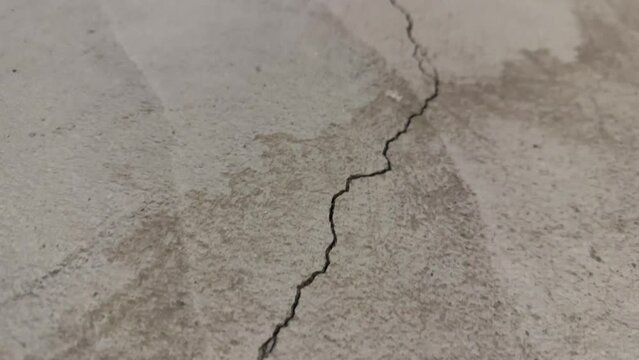 Close up of one long crack in concrete foundation in basement from settling home