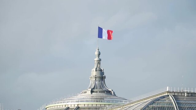 French Flag On Historical Dome Architecture Waving Against Clear Sky In Paris, France. Low Angle