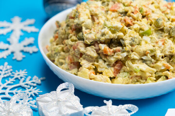Olivier Russian salad, Christmas and New Year food, blue background, top view.