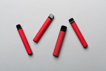 Disposable electronic cigarettes on color background, top view