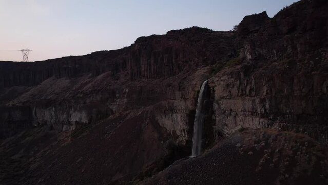 Scenic aerial cinematic footage of Frenchmen coulee waterfall in Washington state during sunset, drone approaching canyon rock formations 
