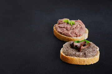 Toasts with meat and mushroom pate on a dark background. Toasts with onion and mushrooms. - obrazy, fototapety, plakaty