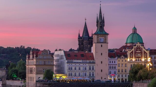 View of the city Prague in Czech Republic with colorful boats day to night transition timelapse on the Vltava river with beautiful sky. Charles bridge on background and Staromestsky water tower