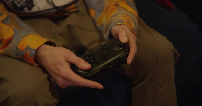 A white teen male playing video games, on a controller.