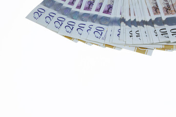 A  spread of ten and twenty pound notes sterling isolated on a white background.