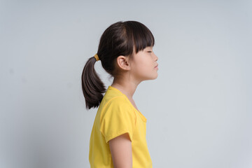 Profile side view face brown-haired little girl standing isolated on white studio background,...