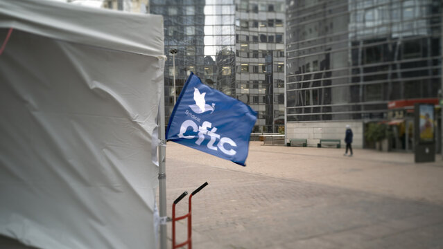 January 12th 2023. A flag with the CFTC syndica logo. Protest tents at the feet of the business district buildings. 