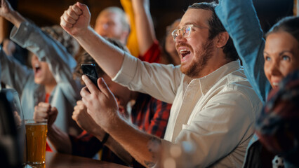 Portrait of a Happy Young Man Holding a Smartphone, Anxious About the Sports Bet on a Soccer Match....