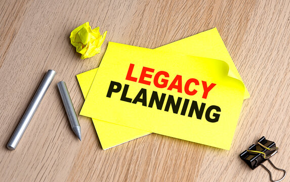 LEGACY PLANNING text on yellow sticky on wooden background
