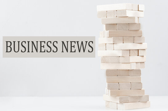 BUSINESS NEWS text with wooden block stack on white background , business concept