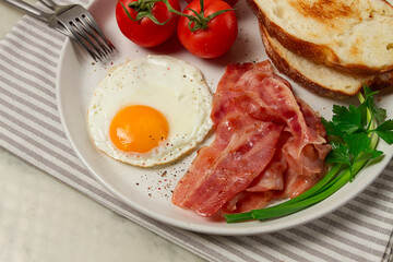 Breakfast, fried egg, bacon and bread, with cherry, on a light background, homemade, no people,