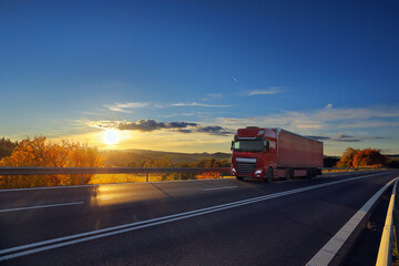 Fototapeta na wymiar Truck transport on the road at sunset and cargo