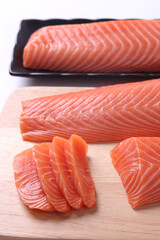 
Salmon sashimi on a wooden chopping board, white background