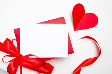 Valentine Day card mockup white red envelope and heart with gift box on white background, top view, flat lay. Blank invitation, flyer, greeting card with holiday decor. Empty love letter