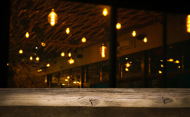 Fototapeta na wymiar Image of wooden table in front of abstract blurred lights of cafe restaurant