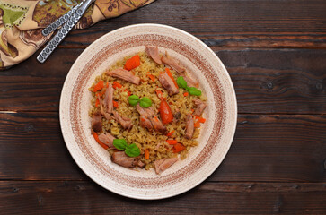 asian dish, uzbek pilaf with meat on a wooden table, flat lay