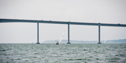 A boat sailing under a bridge on Narragansett Bay, Rhode Island