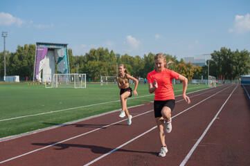 Fototapeta premium Two athlete young girl runner at the stadium outdoors