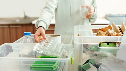 Sorting garbage for recycling. Teen girl is putting plastic package into waste container. Plastic and paper waste segregation, waste sorting, waste recycle.