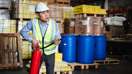 Group of warehouse worker holding a fire extinguisher for prepares for dangerous situations in warehouse factory.