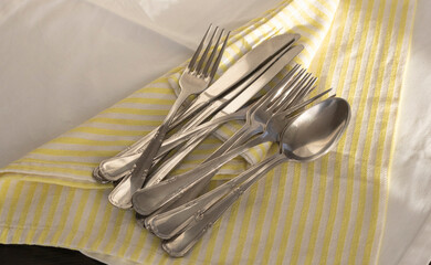 Forks, spoons and knives on a napkin on the table