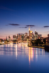 Frankfurt Skyline im Abendlicht mit Lichtern und buntem Himmel.