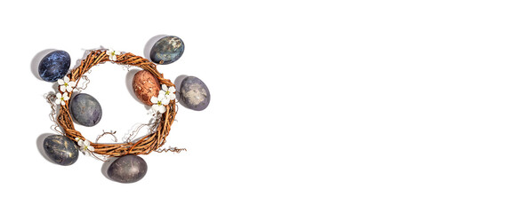 Painted eggs and wicker wreath, blooming cherry isolated on white background. Festive greeting card